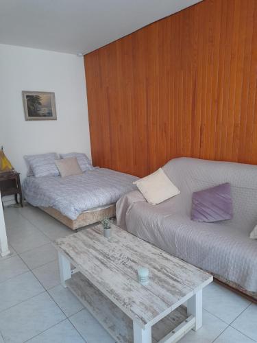 Cette chambre comprend 2 lits et un mur en bois. dans l'établissement La maison bleue, à Palavas-les-Flots