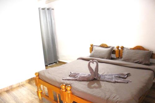Un dormitorio con una cama con una cinta rosa. en Casa Hillary Guest House, en Colva
