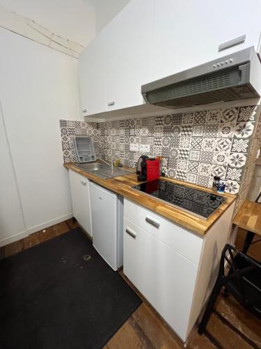 a kitchen with white cabinets and a counter top at Les Studios du Centre Historique de Valence in Valence