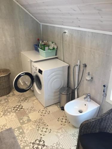 een badkamer met een wasmachine en een wastafel bij Villa Hegeland in Vråliosen