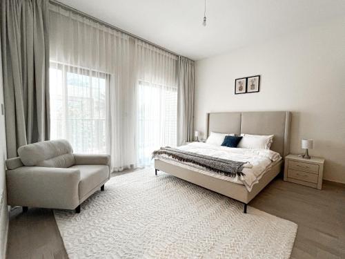 ein Schlafzimmer mit einem Bett, einem Stuhl und einem Fenster in der Unterkunft Luxury Villa by the sea in Fudschaira
