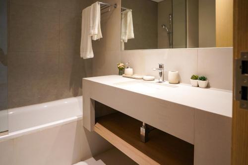 a bathroom with a white sink and a bath tub at Luxury Villa by the sea in Fujairah
