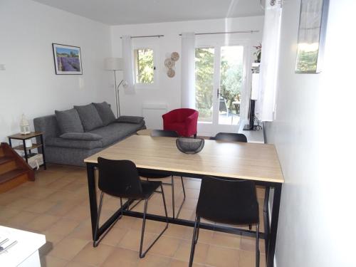 un salon avec une table et des chaises en bois dans l'établissement LES CISTES, à Lioux