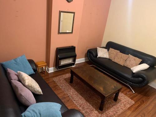 a living room with a couch and a coffee table at Nice 4 bedroom house in Nottingham