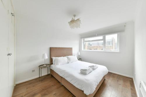 a white bedroom with a bed and a window at The Elden - No 9 - Fairway Hosting in London