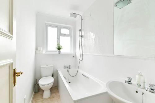 La salle de bains blanche est pourvue de toilettes et d'un lavabo. dans l'établissement The Elden - No 9 - Fairway Hosting, à Londres