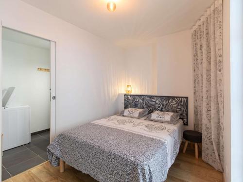 une chambre avec un lit dans une pièce blanche dans l'établissement Appartement Grand Confort, 4-8 Pers, Centre Cauterets, Balcon, 500m des Pistes - FR-1-401-266, à Cauterets
