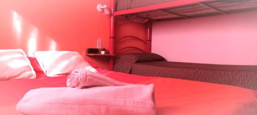 1 dormitorio con 2 camas y pared de color rosa en SPACIO HABITACION APART Baño Privado Estar con microondas y frigobar en Mendoza