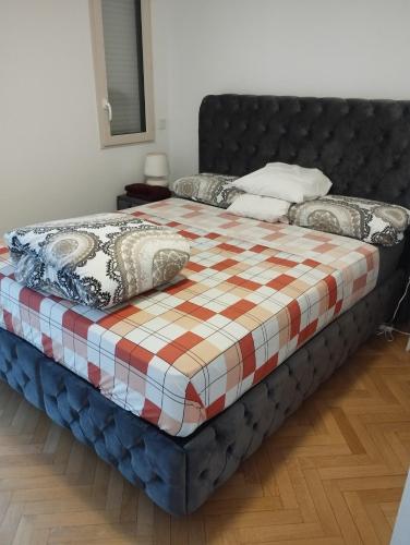 a bed with a checkered blanket and pillows on it at BEAU APPARTEMENT in Suresnes