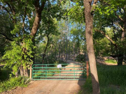 a gate on a dirt road next to a tree at Bonanza Barn Retreat in Loomis