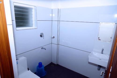 La salle de bains est pourvue d'une douche, de toilettes et d'un lavabo. dans l'établissement Misty Avenue Premium Rooms, à Anachal