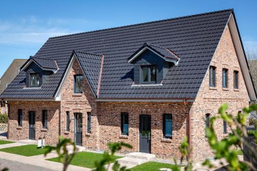 a brick house with a black roof at Haus Jensen 2 in List