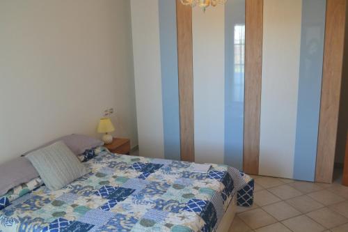 a bedroom with a bed with a quilt on it at Villa Incanto in Forte dei Marmi