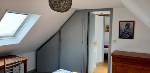 an attic room with a staircase and a window at Gite aux portes de la Pointe du Raz in Poullan-sur-Mer