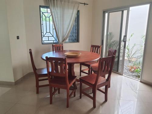 a dining room with a wooden table and chairs at Appartement Seth in Lomé