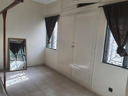 a room with a mirror and some windows at Appartement Seth in Lomé