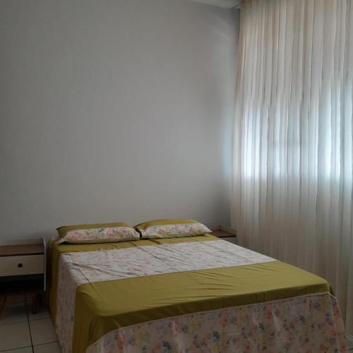 a small bedroom with a bed and a window at Apartamento inteiro e climatizado in Ipatinga