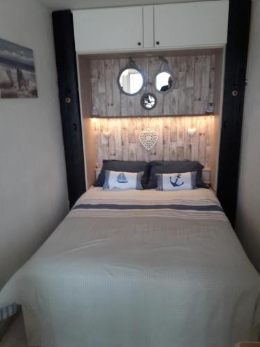 une chambre avec un grand lit avec deux fenêtres dans l'établissement Studio baie Cannes golf piscine mer, à Mandelieu-la-Napoule