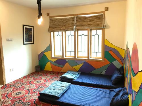a bedroom with a mural on the wall at Hunza Verse in Hunza