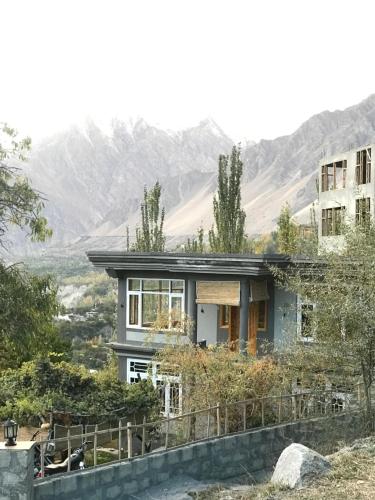 une maison sur une colline avec des montagnes en arrière-plan dans l'établissement Hunza Verse Luxury Home stay, à Hunza