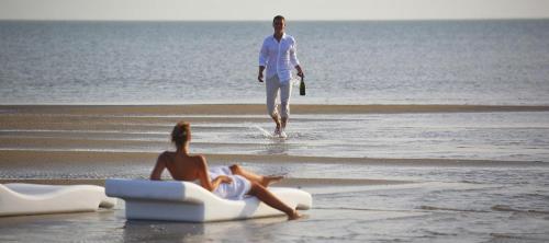 a man and a woman are on the beach at Les Palétuviers in Toubakouta