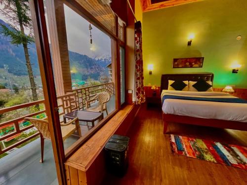 um quarto com uma cama e uma varanda com vista em 4 Bedroom Luxury Bungalow in Manali with Beautiful Scenic Mountain & Orchard View em Manali