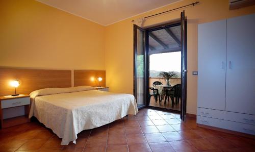 sypialnia z łóżkiem i dużymi przesuwnymi szklanymi drzwiami w obiekcie B&B Fort Apache w mieście Monforte San Giorgio