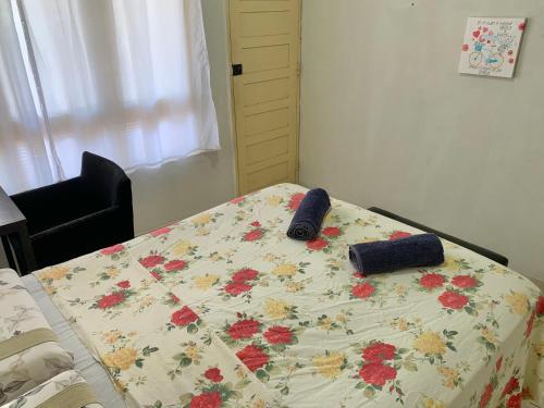 a bed with a blanket with flowers on it at Quarto confortável perto de tudo 03 in Belém