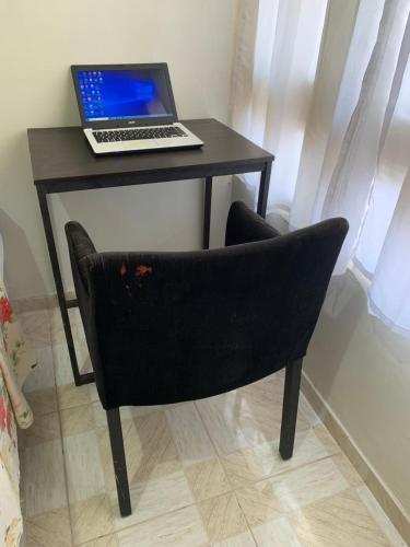 einen Schreibtisch mit einem Laptop auf einem Stuhl in der Unterkunft Quarto confortável perto de tudo 03 in Belém
