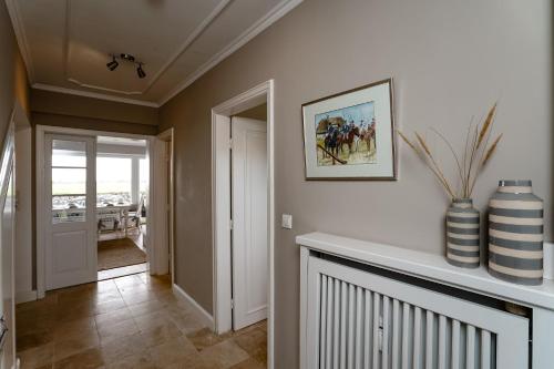 a living room with a vase on a wall at Sylter Seestern Haus Dorfglück in Morsum