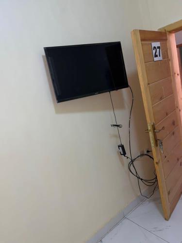 TV de pantalla plana colgada en la esquina de una pared en Chaaban Department, en Nuadibú