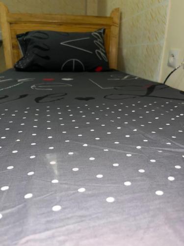 a bed with a black and white comforter on it at Chaaban Department in Nouadhibou
