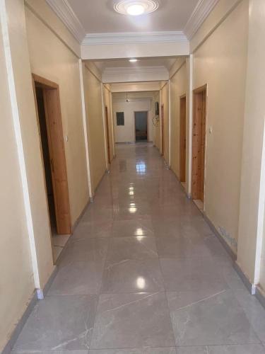 an empty hallway in a building with a tile floor at Chaaban Department in Nouadhibou