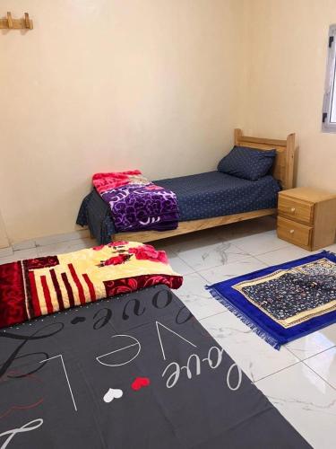 1 dormitorio con cama y alfombra en el suelo en Chaaban Department, en Nuadibú