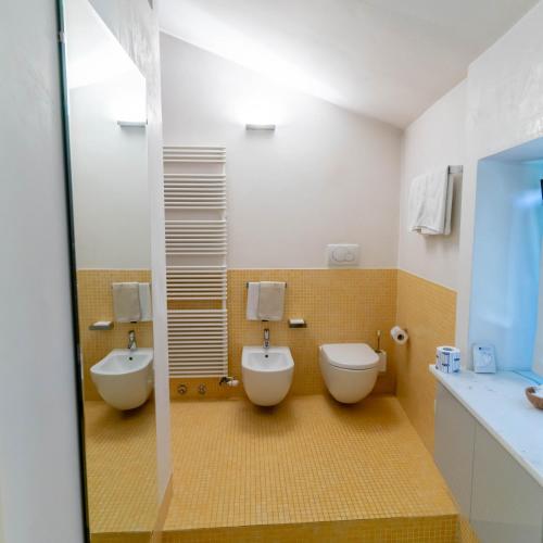 a bathroom with two toilets and a sink at A Casa di Tom in SantʼAmbrogio di Valpolicella
