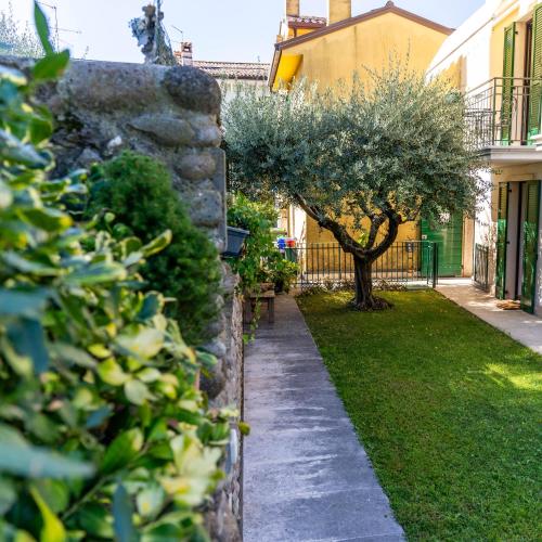 a garden with a stone wall and a tree at A Casa di Tom in SantʼAmbrogio di Valpolicella
