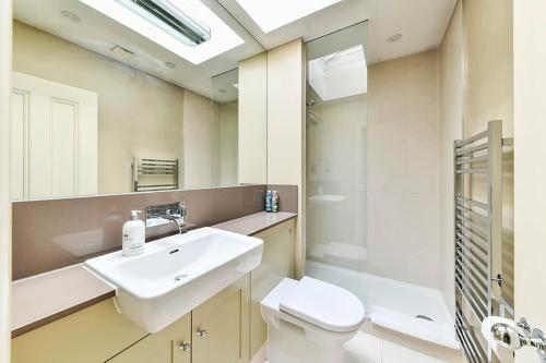 een badkamer met een wastafel, een toilet en een douche bij Fairway Hosting - No 7 in Londen