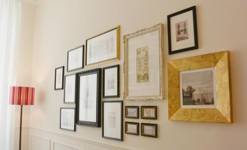 a group of framed pictures on a wall at Alfieri9 in Florence