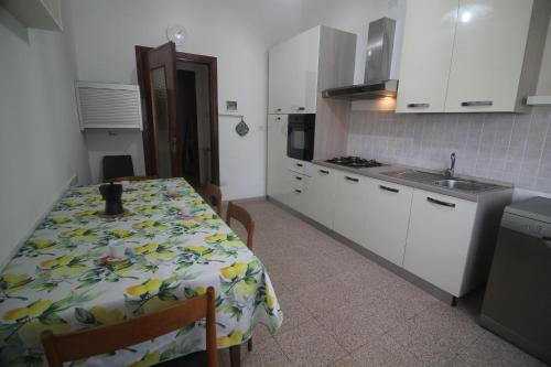 a kitchen with a table and a kitchen with white cabinets at I LIMONI in La Spezia