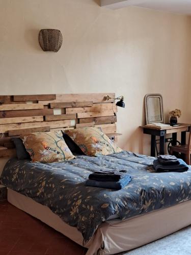 TourouzelleにあるChez Estelle Le SOLのベッドルーム1室(木製ヘッドボード付きのベッド1台付)
