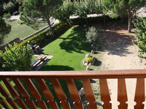 an overlook of a garden with a bench on a balcony at Apartamentos Cal Ratero in Maçanet de Cabrenys
