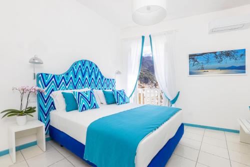 a blue and white bedroom with a bed and a window at YourHome - Adoro Positano in Positano