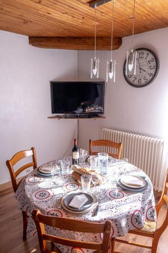 une table avec des assiettes et des verres avec une horloge dans l'établissement Coeur de Charente Maritime, la charentaise, à Saint-Germain-de-Marencennes