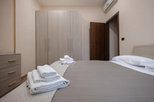 a bedroom with a bed with towels on it at Casa Vacanze Alla Maison in Fiumicino