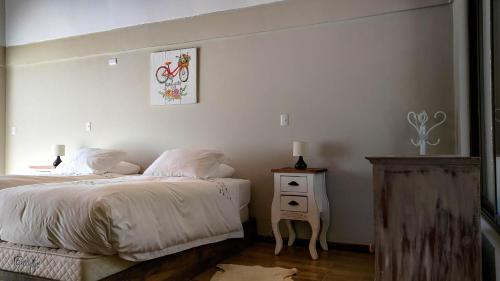 a bedroom with two beds and a table with a picture at Tumuñan Lodge in El Llano