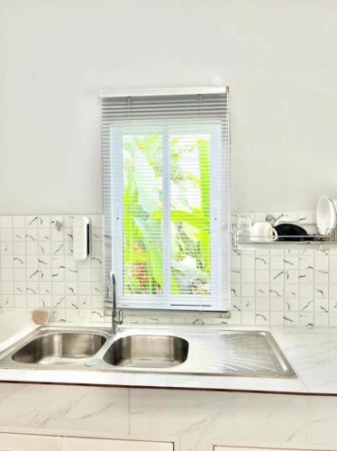 a white kitchen with a sink and a window at Lay Back Villa C2 with Kitchen & High speed Internet in Krabi