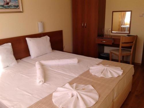 a bedroom with a white bed with towels on it at Stephanovy Guest House in Sozopol