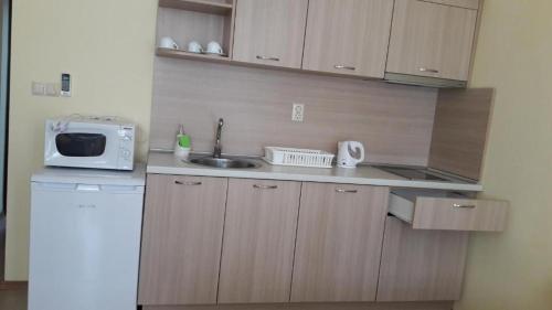 a small kitchen with a sink and a microwave at Stephanovy Guest House in Sozopol