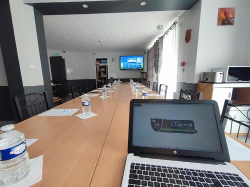 a laptop computer sitting on top of a long table at Résidence L'Ogomé in Le Boupère