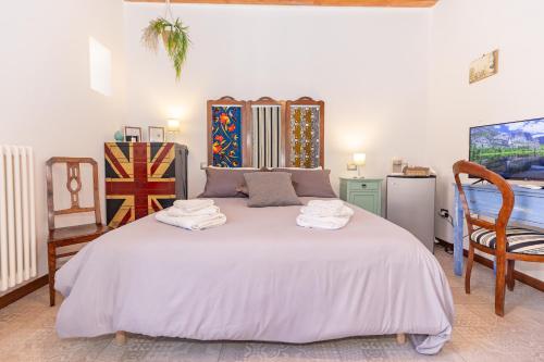 a bedroom with a large white bed with towels on it at CENTRO STORICO Redmood House a 5 min dal Mare, Aria Condizionata, Wi-Fi e Netflix in Barletta